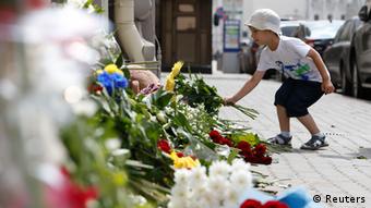 A boy places flowers outside the Dutch embassy in Moscow. (Photo: REUTERS/Sergei Karpukhin)