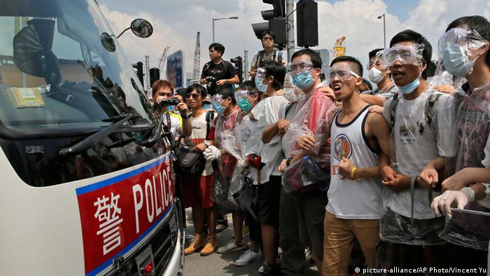  Protesters wear masks and goggles to protect themselves from pepper spray while blocking a police car outside the government headquarters in Hong Kong, Sunday, Sept. 28, 2014. (AP Photo/Vincent Yu)