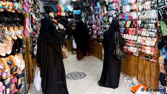 Γυναίκες με μαντήλες αγοράζουν παπούτσια σε κατάστημα στη Ράκα