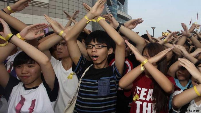 Joshua Wong with his arms up protesting in Hong Kong 