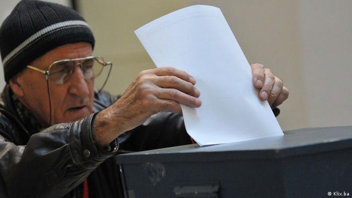 Stariji muškarac ubacuje glasački listić u kutiju