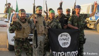 شبه‌نظامیان شیعه عراقی که پرچم گروه دولت اسلامی را به غنیمت گرفته‌اند