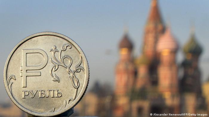 Монета в один рубль на фоне собора Василия Блаженного