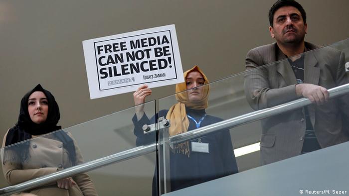 Zaman journalist holds a placard at the headquarters of Zaman daily newspaper. (Photo: REUTERS/Murad Sezer)