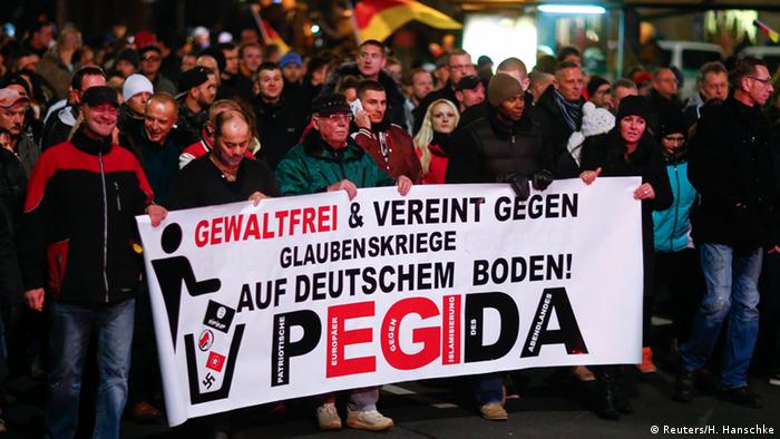  Participants hold a banner during a demonstration called by anti-immigration group PEGIDA, a German abbreviation for Patriotic Europeans against the Islamization of the West, in Dresden December 15, 2014. Several thousands opponents of Germany's policy towards asylum seekers and Islam took part in the protest in the eastern German town on Monday. The banner reads, Peaceful and united against wars of religion in Germany! REUTERS/Hannibal Hanschke 