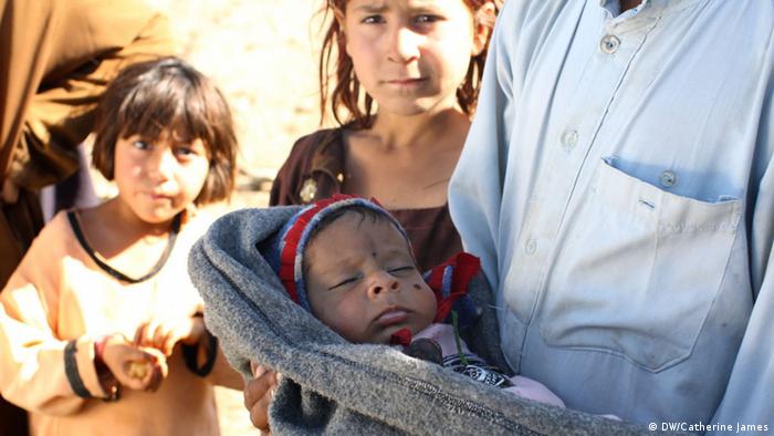 A man holds Samidullah in his arms