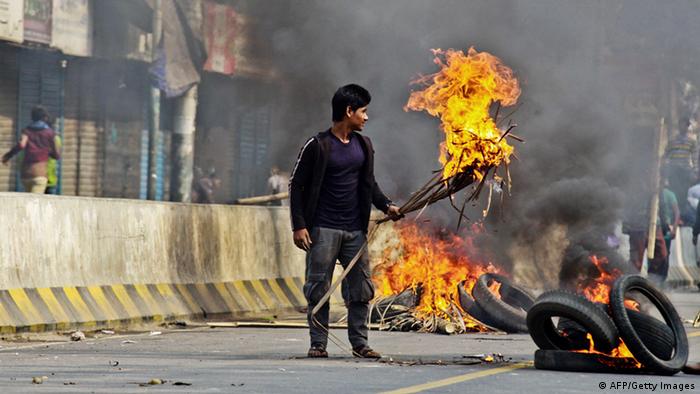 Bangladesh Nationalist Party (BNP) supporters set fire to tyres and material in the street during a clash with police outside a court in Dhaka on December 24, 2014, during a court appearance by party chief Khaleda Zia (Photo: STRDEL/AFP/Getty Images)