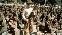 یک کودک‌سرباز ایرانی در آوریل ۱۹۸۲ در جلوی صف اسیران عراقی در دزفول با اسلحه ژست می‌گیرد
