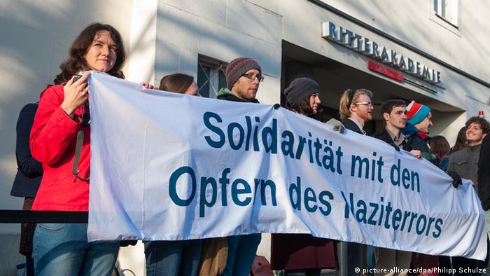 گروهی از فعالانی که برای اعلام همبستگی خود با قربانیان جنایات نازی‌ها مقابل دادگاه اسکار گرونینگ تجمع کردند 