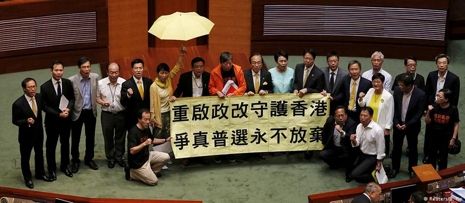 Deputados da oposição exibem faixa contra o projeto de lei no plenário do parlamento