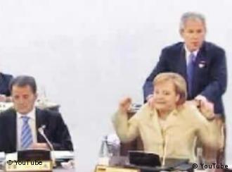 YouTube screenshot of Bush massaging Chancellor Merkel's shoulders while she's seated in a chair