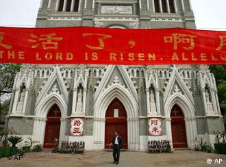 A Christian worshiper walks underneath a banner that reads the lord has risen, alleluia shortly after mass at one of Beijing's state controlled churches in China Friday May 5, 2006. The Vatican has lashed out at China, announcing the excommunication of two bishops who were ordained by Beijing's state-controlled church without Pope Benedict XVI's consent and deploring what it called coercion against the prelates. Benedict's first major political clash since his election as pontiff a year ago dimmed hopes for any re-establishment soon of official ties between the Holy See and Beijing that ended after officially atheist communists took control of China in 1949. (AP Photo/Elizabeth Dalziel)