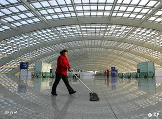 A worker cleans at the high speed rail terminal at the new Terminal 3 building at Beijing Airport. The terminal, which opens Friday, is a centerpiece project for the 2008 Olympics and is designed to relieve the overloaded airport's other two terminals and accommodate expected rapid growth in the number of visitors to Beijing. The huge, airy terminal will have 64 Western and Chinese restaurants, 84 retail shops, and a state-of-the-art-baggage handling system. Six airlines will begin flying into the terminal Friday, while others will switch over in March. (AP Photo/Greg Baker)
