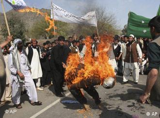 Afghan students burn an effigy during a demonstration against the reproduction of cartoons depicting the Prophet Muhammad in Danish newspapers and an upcoming Dutch film criticizing the Quran in Jalalabad, the provincial capital of Nangarhar province, east of Kabul, Afghanistan, on Sunday, March 9, 2008. Thousands of Afghan students chanted slogans and burned Danish and Dutch flags Sunday in the latest in a series of protests over perceived insults to Islam. (AP Photo/Rahmat Gul)