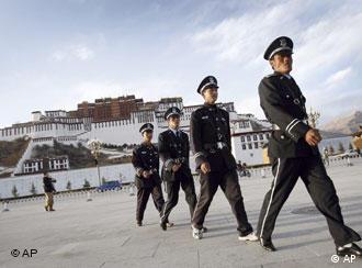 Chinese security officers patrol a square with the Potala Palace, the Dalai Lama's former residence, seen at the background in Lhasa, capital of southwest China's Tibet Autonomous Region, China, Wednesday, March 26, 2008. The first group of foreign journalists allowed into Tibet since anti-government riots broke out has arrived in Lhasa on Wednesday. (AP Photo/Andy Wong) 