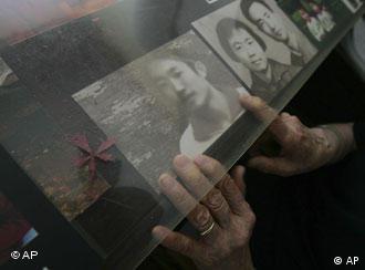 Ding Zilin, co-founder of the Tiananmen Mothers, a group representing families of those who died in the 1989 crackdown on pro-democracy demonstrations, arranges a photo of her son, Jiang Jielian, at her apartment in Beijing Wednesday June 4, 2008. Wednesday is the 19th anniversary of the military assault in which hundreds, possibly thousands, were killed as Chinese troops shot their way through the city to end weeks of protests in Tiananmen Square. Ding's 17-year-old son was killed in the assault. (AP Photo/Greg Baker)