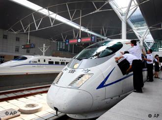 Chinese railway employees cleans the new high-speed CRH3 train as its arrived at the Tianjin Railway Station, China, during a trial run on the new Beijing-Tianjin line, Tuesday, July 22, 2008. A new high speed train link between Beijing and Tianjin, where Olympic soccer matches will be played, is scheduled to open on Aug 1. The train, which can run at speeds up to 350 kph, will cut the travel time between the two Olympic cities from 1 hour, 10 minutes to 25-30 minutes. (AP Photo/Andy Wong)