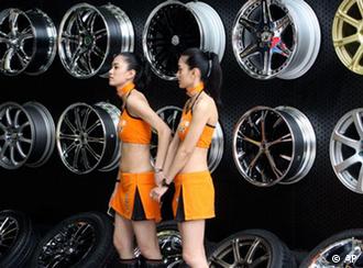 Models stand in front of wheels at Dunlop exhibition booth at the Shanghai International Auto Show on its opening day, Monday, April 20, 2009 in Shanghai, China. World automakers were launching 13 new models Monday as they converged on China's commercial capital for the show, a key showcase for the only major growing car market. (AP Photo/Eugene Hoshiko) 