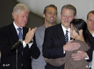 Former Vice President Al gore, center, hugs Laura Ling as former President Bill Clinton looks on at Bob Hope Airport in Burbank, Calif., Wednesday, Aug. 5, 2009. Ling and Euna Lee, the two American journalists freed by North Korea, returned home to the United States on Wednesday for a jubilant, emotional reunion with family members and friends they hadn't seen since their arrests nearly five months ago. (AP Photo/Jae C. Hong)