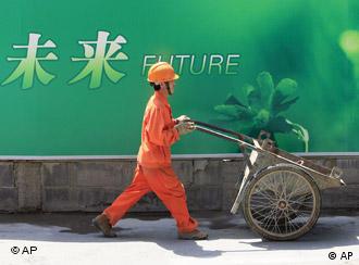 In this June 25, 2009 photo, a migrant worker pushes a cart at a construction site in Shanghai, China. China has seen a rebound in the employment of migrant workers, with 150 million employed outside their hometown by the end of June, a Chinese official said Friday. The financial crisis hit China's export sector hard, sending more than 20 million migrant workers back to the countryside from their jobs in coastal areas, the government reported in February. (AP Photo/Eugene Hoshiko)