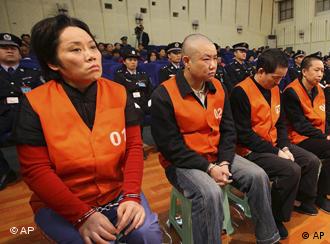 Xie Caiping, left, and other gangster suspects stand trial at the Chongqing No.5 Intermediate People's Court in Chongqing, China,  Tuesday, Nov. 3, 2009. The woman called the "godmother" of a mafia-style gang in China's southern city of Chongqing was sentenced to 18 years in prison Tuesday for running underground casinos and bribing government officials. (AP Photo) ** CHINA OUT **