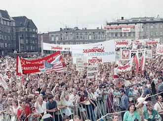 Thousands of Polish citizens with solidarity posters and banners fill the place around the Lenin Shipyard Memorial in Gdansk, Tuesday, July 11, 1989. (AP Photo/Charles Tasnady)