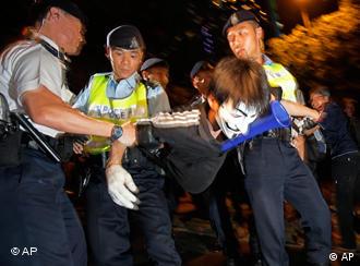 Pro-democracy protester is taken by the police officers at the government headquarter during the demonstration in Hong Kong Thursday July 1, 2010. Hecklers besieged Hong Kong's Democrats at the opposition camp's flagship protest march Thursday, accusing them of selling out their cause by striking a deal with Beijing on conservative electoral changes in the semiautonomous Chinese territory. Several protesters approached the several hundred Democratic Party members who took part in the demonstration, chanted "Betraying Hong Kong at a critical moment" and briefly quarreled with party supporters. Others held signs condemning the Democrats, while some sold T-shirts that portrayed the party symbol, a dove, with the Chinese national flag for a heart.  (AP Photo/Vincent Yu)