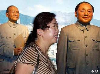 A Chinese woman walks past wax figures of former Chinese leaders Chen Yun, left, and Deng Xiaoping at a newly opened Wax Museum in Beijing, China Friday, Aug. 2, 2002. A first batch of 35 life like statues of popular figures in China's modern history is being presented to the public as the largest of its kind in the country. Some 300 to 400 waxwork figures are planned for the completion of the project in 2007