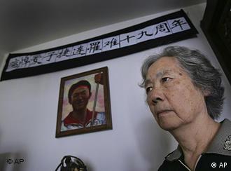 FILE - In this Juen 4, 2008 file photo, Ding Zilin, co-founder of the Tiananmen Mothers, a group representing families of those who died in the 1989 crackdown on pro-democracy demonstrations, stands in front of a shrine to her son, Jiang Jielian, who died at 17, at her apartment in Beijing, marking the 19th anniversary of the military assault in Tiananmen Square. In the week after Liu Xiaobo won for his decades of promoting democratic change in China, dozens of people who openly agreed with his views say they have been detained, roughed up, harassed or kept from leaving their homes. The latest appears to be a woman who Liu has said should win the prize: Ding Zilin, who has fought for years for China's government to recognize the hundreds killed in the military's crackdown.  Liu's wife sent out an alert late Thursday, Oct. 14, 2010, that said Ding had "disappeared" and urged people to "pay attention" to her case. (AP Photo/Greg Baker, File)