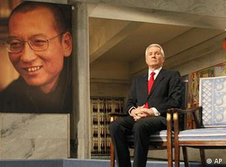 The chairman of the Norwegian Nobel Committee, Thorbjoern Jagland, sits next to an empty chair during the ceremony in Oslo City Hall to honour this years Nobel Peace Prize winner, jailed Chinese dissident Liu Xiaobo whose picture hangs at left and is represented by the empty chair. (AP Photo Heiko Junge, pool)