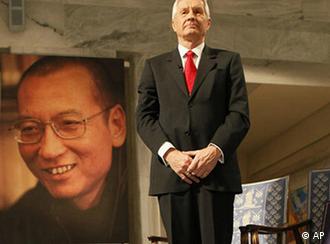 Chairman of the Norwegian Nobel Committee Thorbjoern Jagland poses next to  the Nobel diploma and Nobel medal placed on the empty chair during the ceremony in Oslo City Hall Friday Dec. 10, 2010 to honour in absentia this years Nobel Peace Prize winner, jailed Chinese dissident Liu Xiaobo.  (AP Photo Heiko Junge, pool)