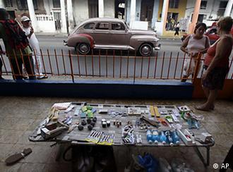 Magaly Dopico, far right, talks with a customer as an array of goods lay on display on a lawn chair in front of her home in the neighborhood of El Cerro in Havana, Cuba, Tuesday Jan. 18, 2011. Cuba began a public debate over landmark plans to lift the island's struggling economy by liberalizing some private enterprise, streamlining its vast state bureaucracy by laying off a half-million workers and repaying billions of dollars in debt. (AP Photo/Javier Galeano)