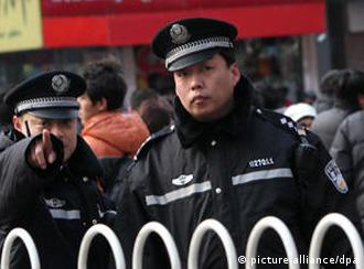 epa02604601 A policeman guarding the entrance to Wangfujing street points to a photographer in central Beijing, China, on 27 February 2011. Police barred foreign reporters from the site of a planned anti-government protest in Beijing 27 February amid the tightest security in the Chinese capital since the 2008 Olympic Games. Scores of uniformed and plain-clothes police moved people away from the area around a fast food restaurant in the nearby Wangfujing shopping street where activists called for weekly protests each Sunday afternoon. EPA/HOW HWEE YOUNG  +++(c) dpa - Bildfunk+++  ### usage Germany only, Verwendung nur in Deutschland ###