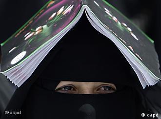 A female anti-government protestor covers her head with a book to avoid the sun while taking part in a demonstration demanding the resignation of Yemeni President Ali Abdullah Saleh, in Sanaa, Yemen, Thursday, March 17, 2011. Witnesses said government supporters have attacked protesters camped out at a square in the Yemeni capital demanding the country's ruler of 32 years to step down. (Foto:Muhammed Muheisen/AP/dapd)