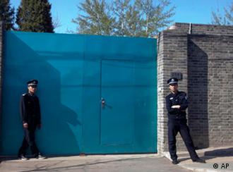 A Chinese police officer, right, and a security guard stand outside the entrance to Ai Weiwei's studio in Beijing Sunday, April 3, 2011. China blocked Ai Weiwei, one of its most famous contemporary artists, from taking a flight to Hong Kong on Sunday and police later raided his Beijing studio, the man's assistant said. (AP Photo/Ng Han Guan)