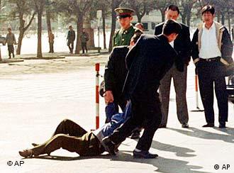 Plainclothed police officers drag away a man who tried to present a petition outside Beijing's Great Hall of the People, where the National People's Congress is being held Thursday, March 12, 1998. Police have detained many people who have attempted to petition lawmakers during the two-week annual meeting of China's legislature. (AP Photo/Ahn Youn-joon)