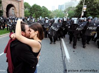 A man and a woman kiss as riot police advance during a protest against the G-20 and the G-8 summits in Toronto, Ontario, Canada on 26 June 2010. The summits, which bring together world leaders and foreign ministers, are being held in the region through the weekend. EPA/JUSTIN LANE 